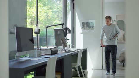 male floor plan technician measures floor to ceiling in modern home