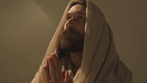 Studio-Portrait-Of-Man-Wearing-Robes-With-Long-Hair-And-Beard-Representing-Figure-Of-Jesus-Christ-Praying-5