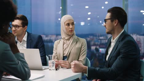 Hombre-De-Negocios-Discutiendo-Ideas-De-Negocios-Con-Una-Mujer-Musulmana-En-Una-Conferencia-De-Negocios-En-La-Oficina