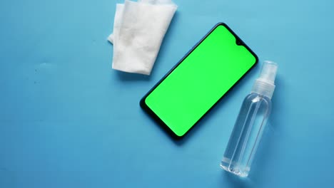 cleaning a smartphone with wipes and spray bottle