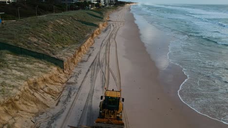 Heavy-machinery-picking-up-rubbish-from-a-beach-that-was-damaged-by-a-recent-cyclone-swell-and-high-tide