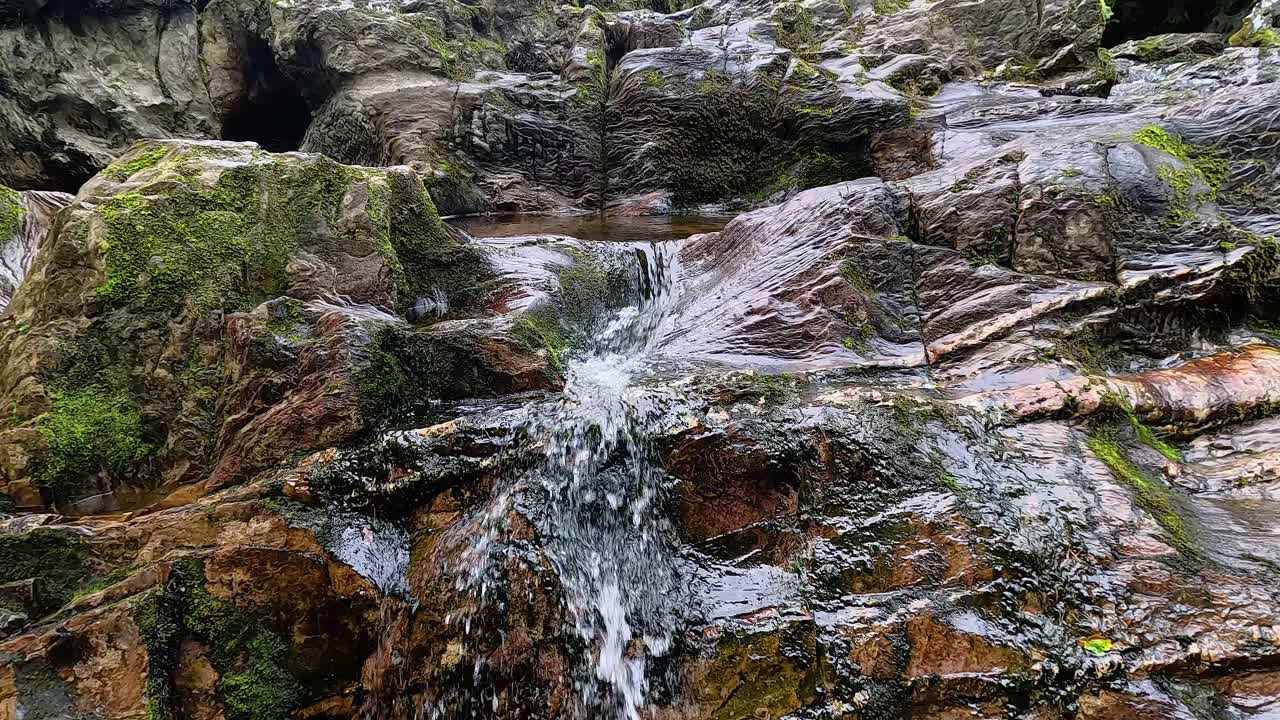 Cascading waterfall over mossy rocks