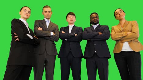 grupo de colegas de pie y doblar los brazos, mirando serio en una pantalla verde, clave de croma