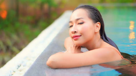 close-up of beautiful smiling asian woman relaxing in pool alone