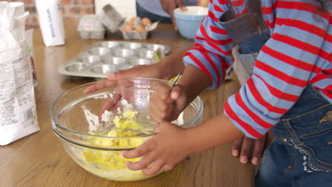padres e hijos horneando pasteles en la cocina juntos