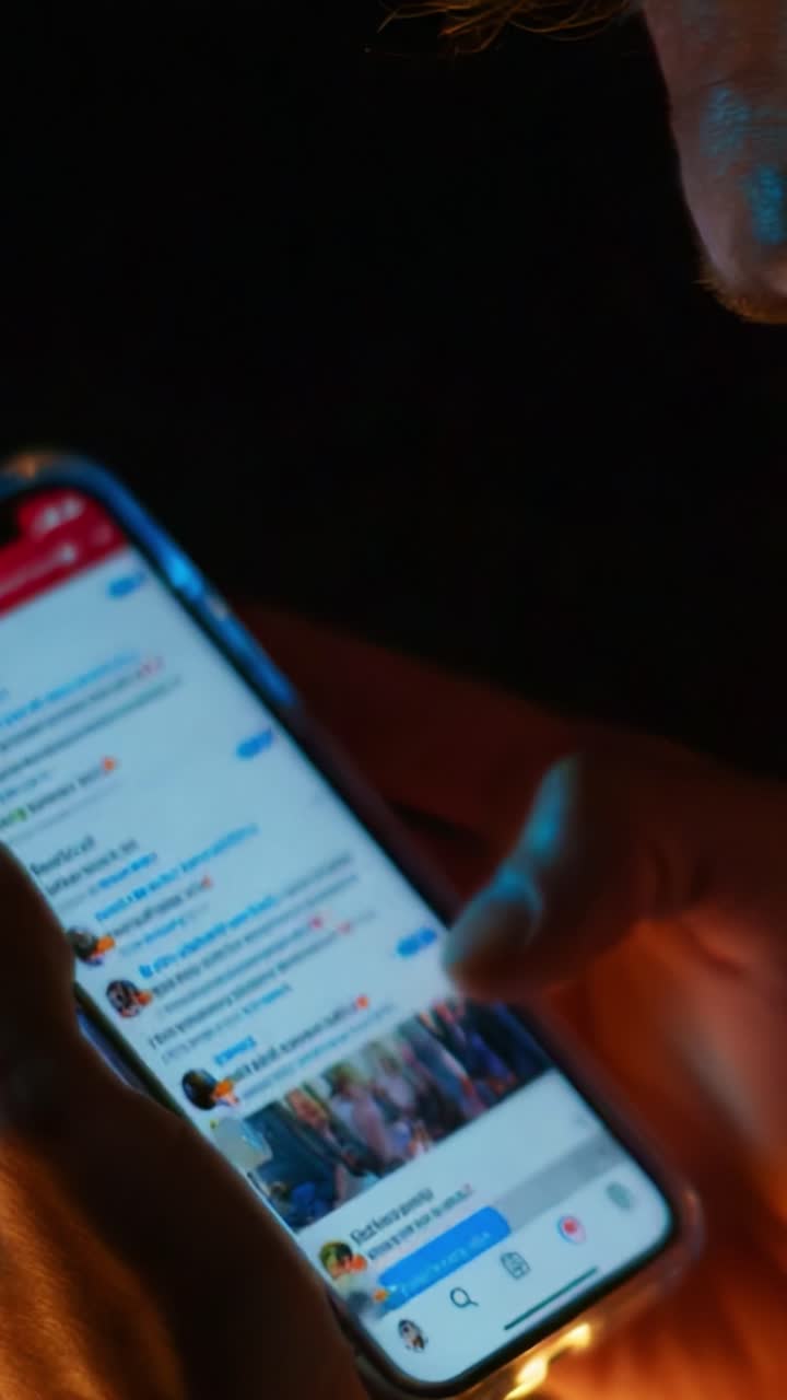 A Close-Up View of a Person Engaged in a Texting Conversation on Their Smartphone, Highlighting the Intimate Interaction with Mobile Technology in a Dimly Lit Environment