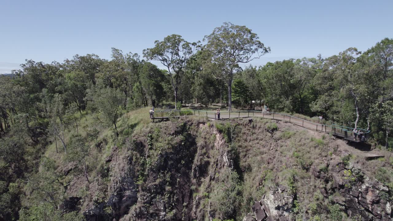mujer en el mirador de wallaman falls agitando las manos en el aire