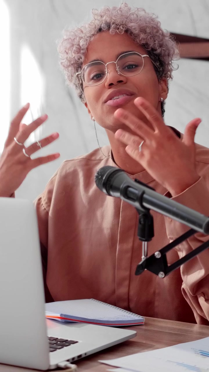 Ung afrikansk-amerikansk kvinde optager podcast i moderne hjemmestudie