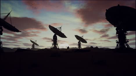 antenas parabólicas en el campo contra el cielo nublado durante la puesta del sol