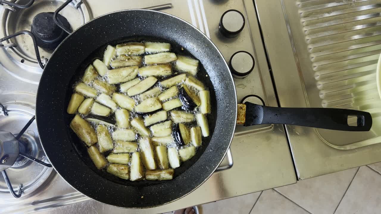 berenjenas vegetarianas fritas en una sartén en aceite vegetal