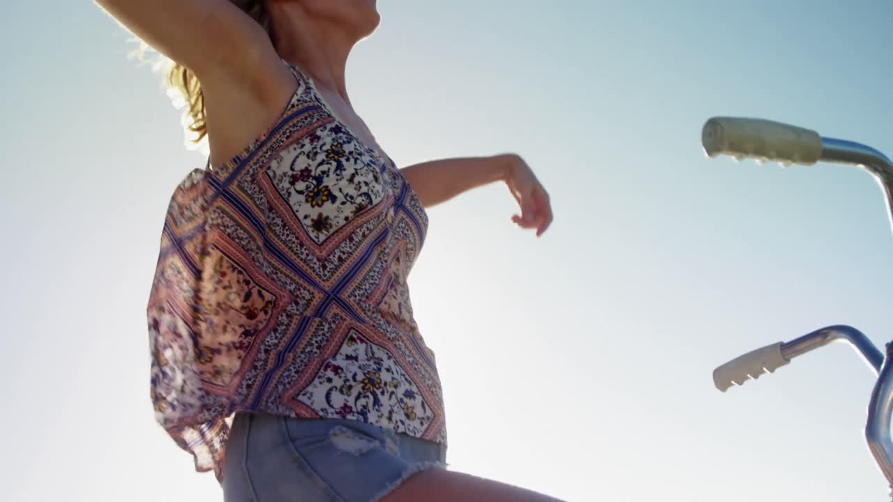 자전거 에 팔 을 펴고 앉아 있는 젊은 여자