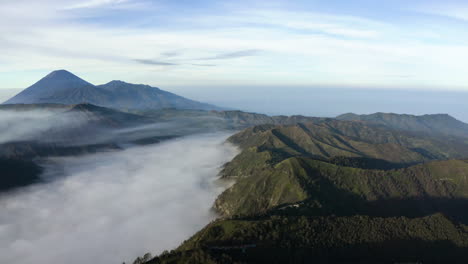 aerial view overlooking mountains and a foggy valley in the tengger, east java, indonesia