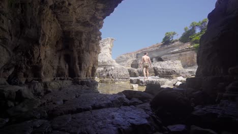 un joven caminando por los acantilados del mar.