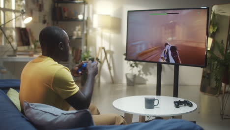 man playing a video game in his living room