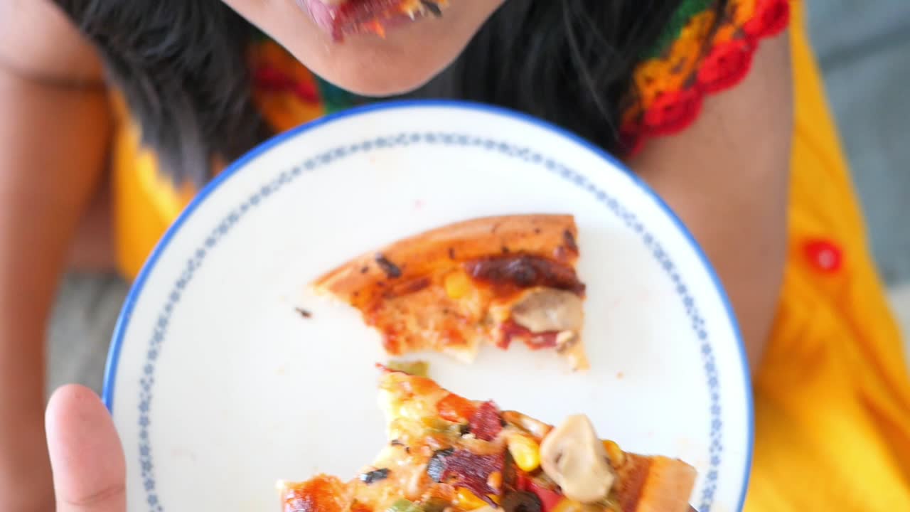 una niña comiendo una rebanada de pizza