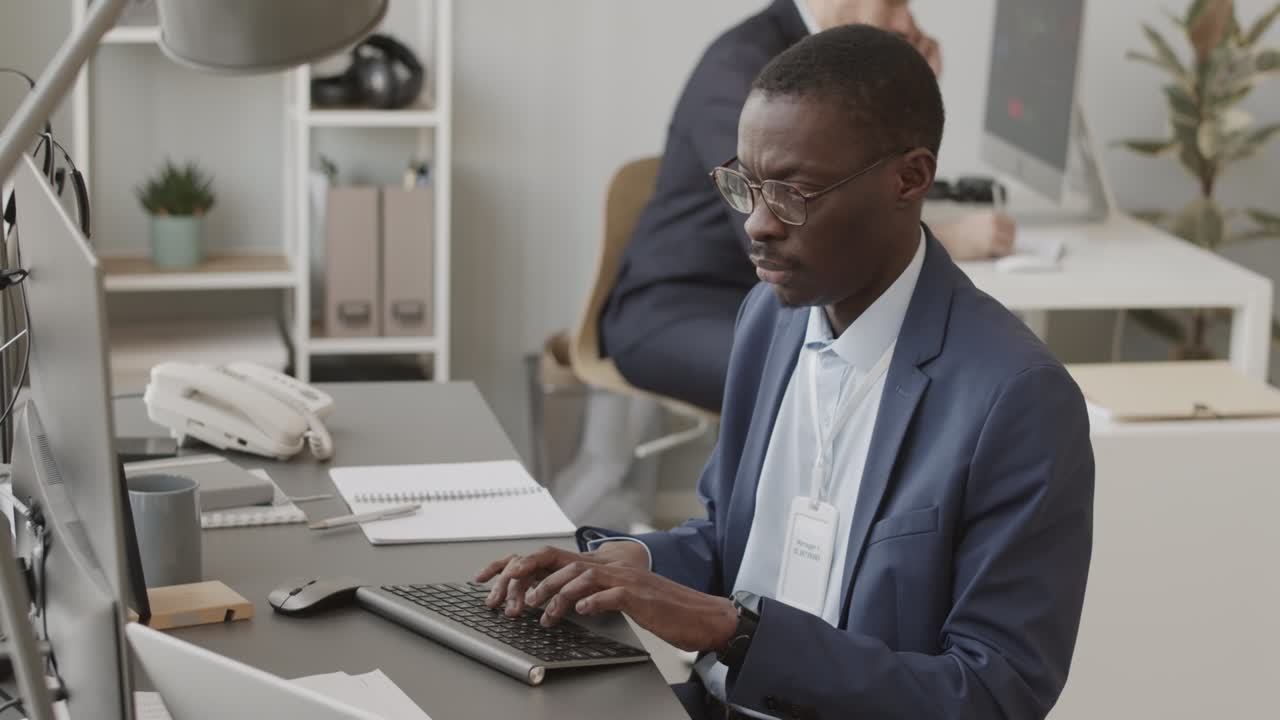 African American Fund Manager Working on Computer in Office