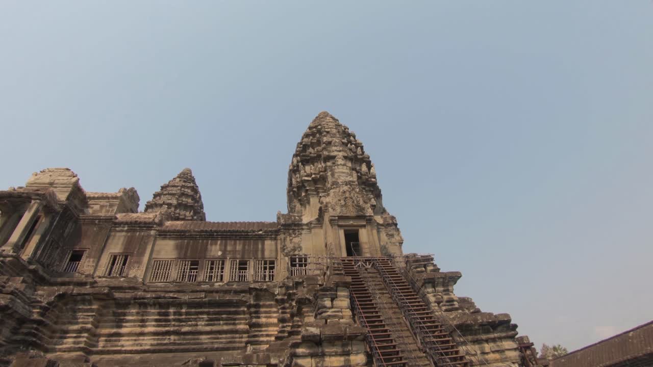 Pan through a doorway towards a tower of the temples Angkor Wat in Cambodia