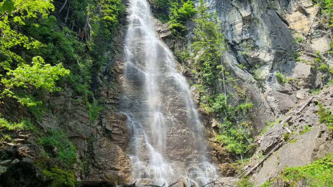 Revealing shot of the alpine waterfall at Schwarzsee, Switzerland, a popular destination for both tourists and local visitors