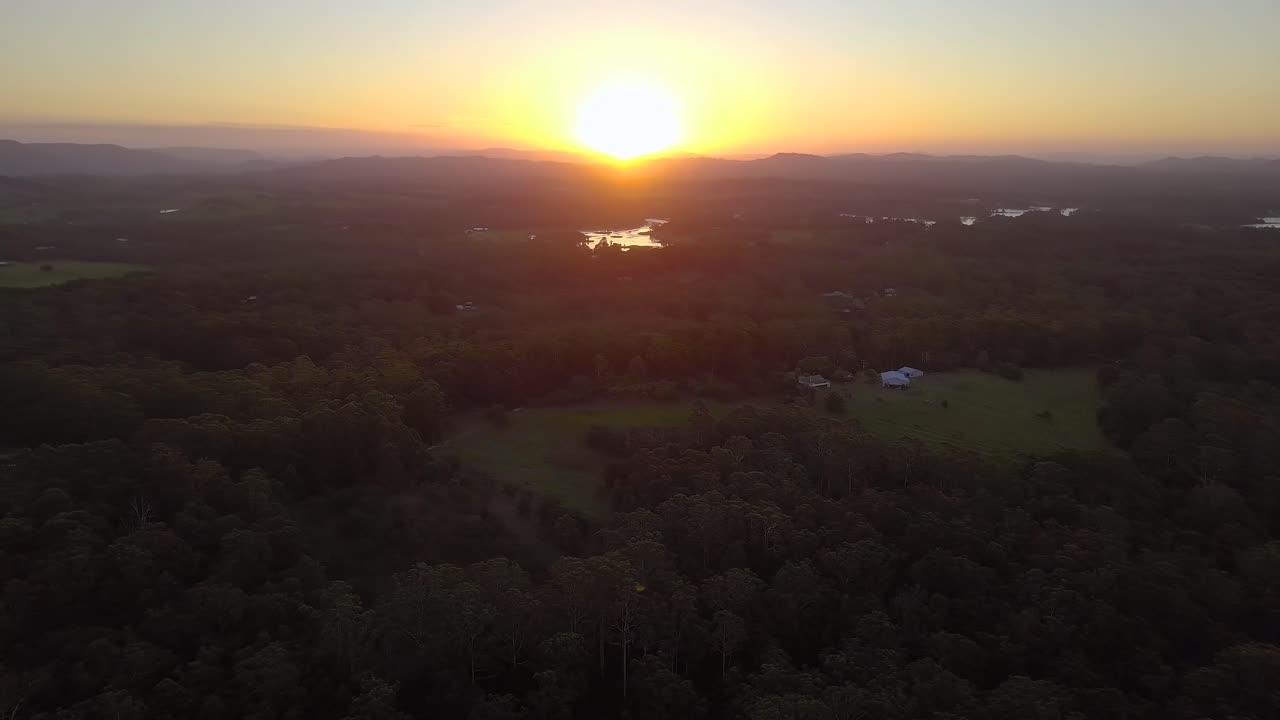 숲과 산이 있는 선샤인 코스트에서 놀라운 황금빛 분홍빛 일몰을 공중 드론으로 볼 수 있습니다.