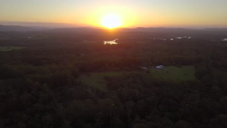 Luftdrohnenansicht-Des-Erstaunlichen-Goldenen-Rosa-Sonnenuntergangs-An-Der-Sonnenscheinküste-Mit-Wäldern-Und-Bergen