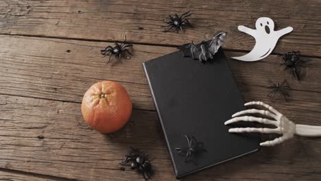 video de manos de esqueleto de halloween, cuaderno y decoraciones con espacio de copia en fondo de madera