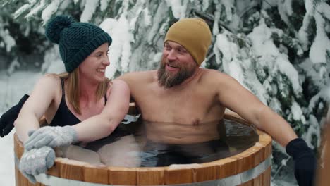 caucasian woman with man during the winter bath in frozen water.