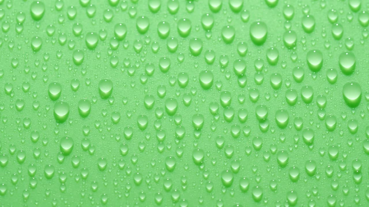 primer plano de la textura de las gotas de agua transparentes que giran sobre el fondo de la llave de croma verde