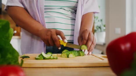 woman cutting cucumber in the kitchen