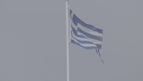 Toma-En-Cámara-Lenta-De-La-Bandera-Griega-En-Grecia-Ondeando-En-El-Viento-En-Un-Día-Brillante-Con-El-Registro-De-Cielo-Azul