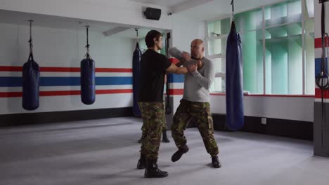 caucasian man learning martial arts from trainer in gym