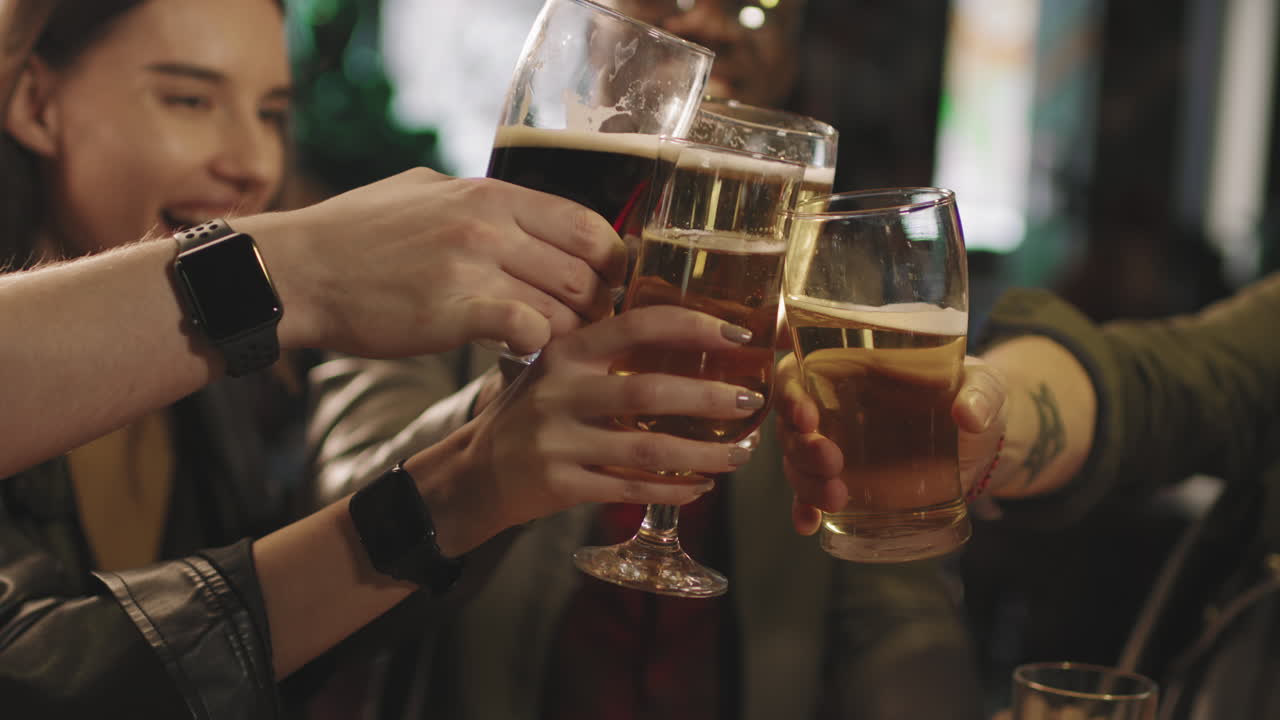 Cheerful Friends Toasting Beer Glasses At Bar