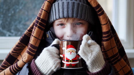 child enjoys a warm holiday drink in winter