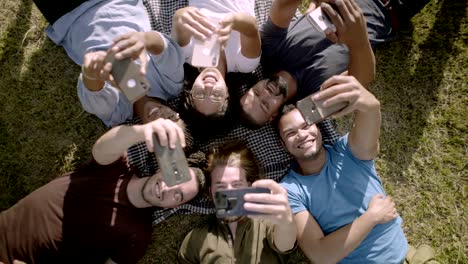 vista de arriba de jóvenes felices usando teléfonos inteligentes.