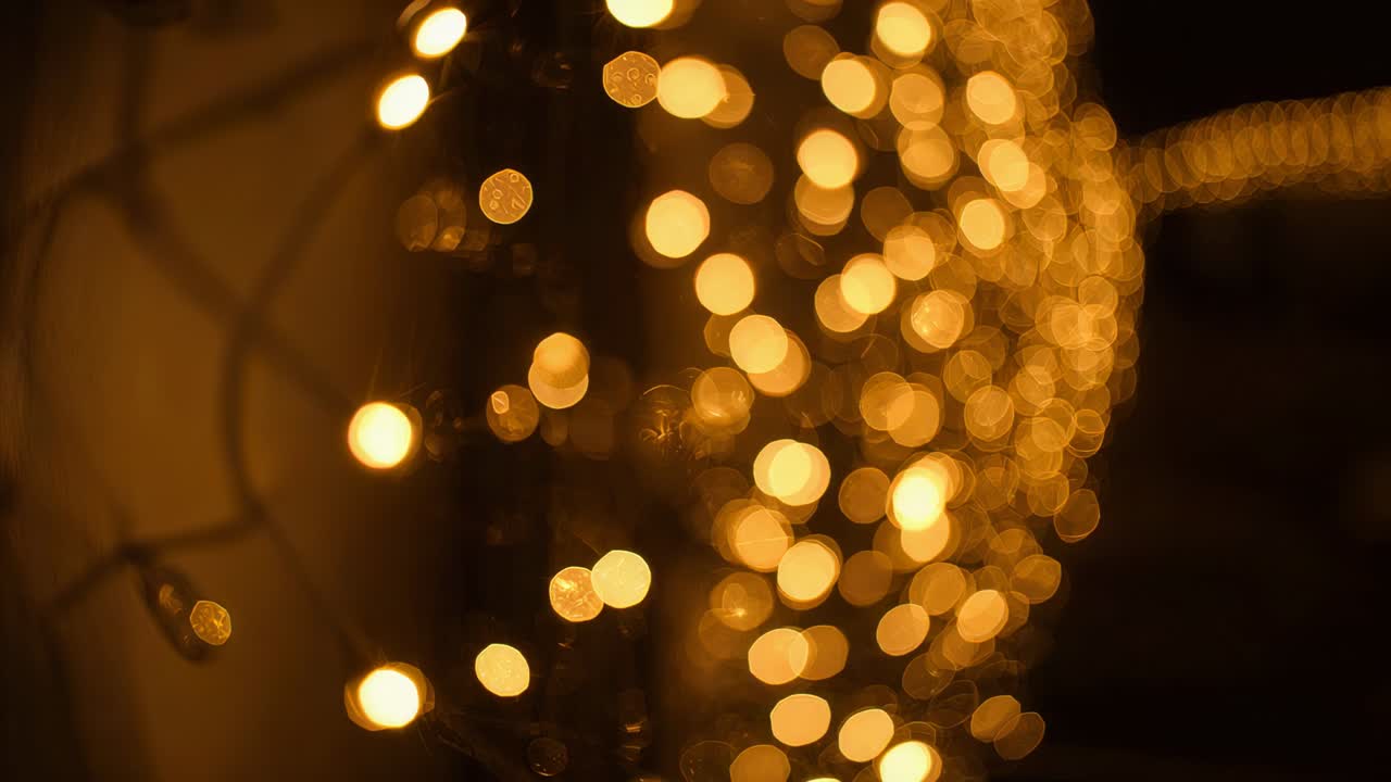 Shifting vertical warm string lights drifting right on balcony as camera pans, with coarse mesh