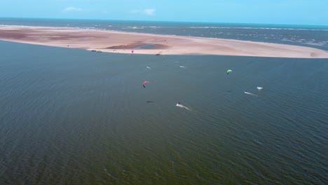 Gruppe-Von-Kitern,-Die-Neben-Einer-Sandbank-Am-Meer-Reiten