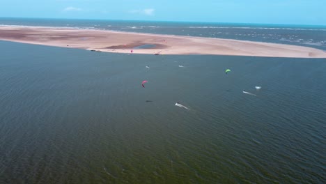 grupo de kiters montando junto a un banco de arena en el mar