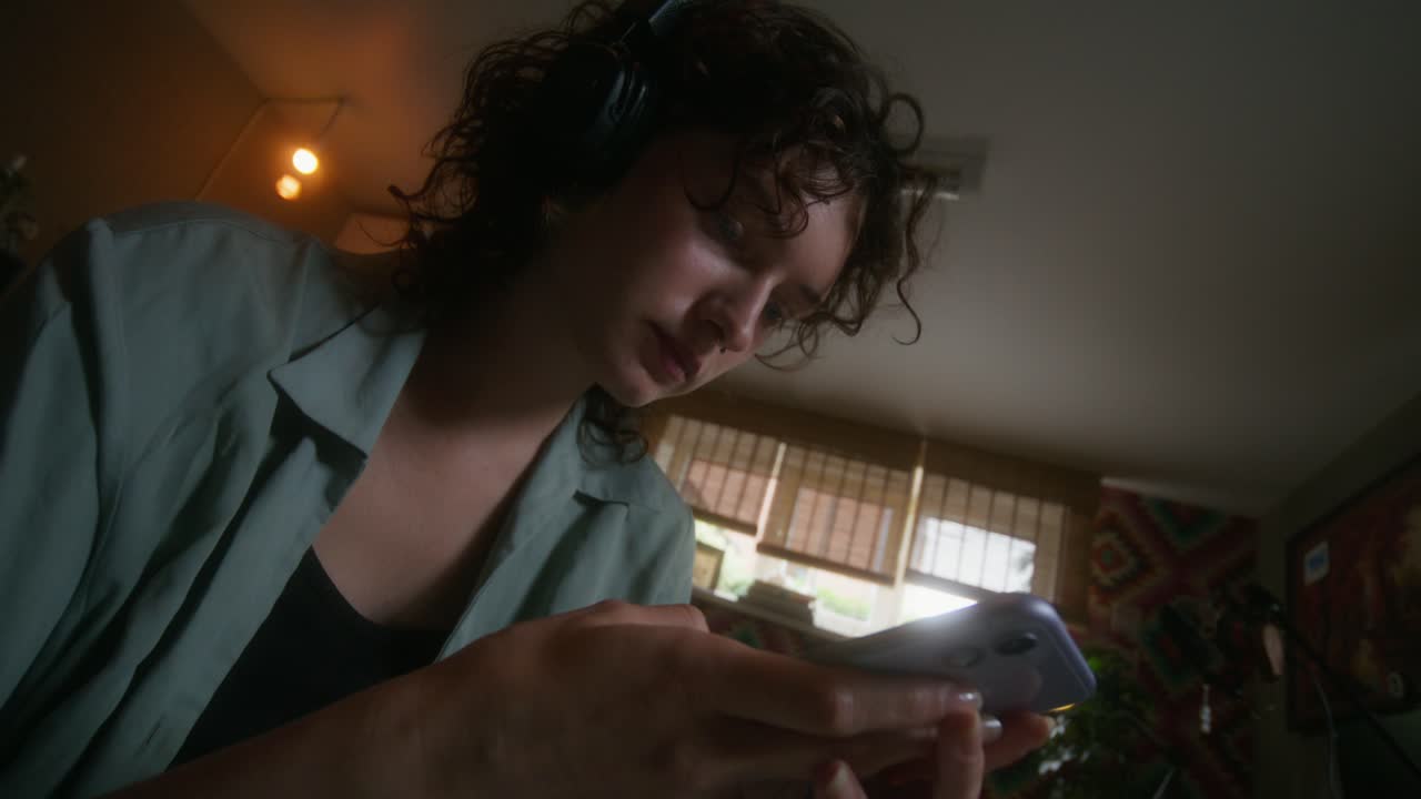 joven usando un teléfono inteligente en una habitación