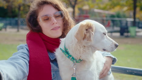 portrait of joyous woman hugging dog in the park