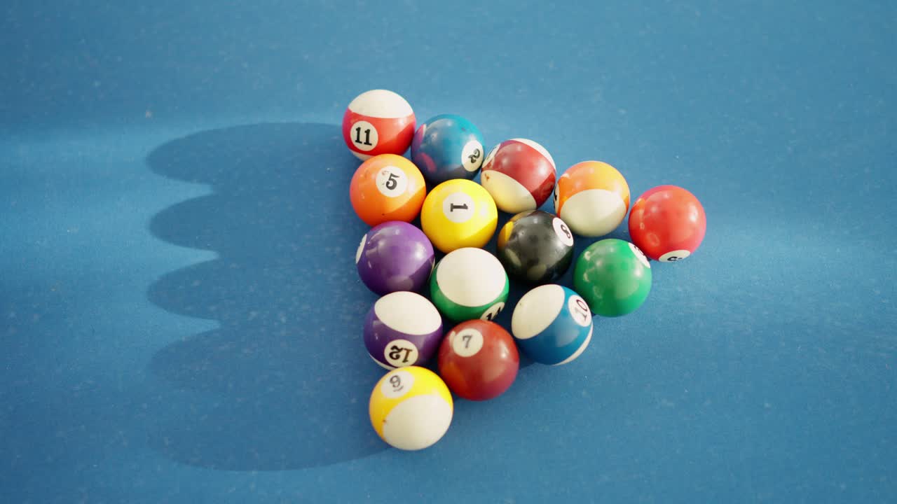 White ball hitting pool balls and spread them