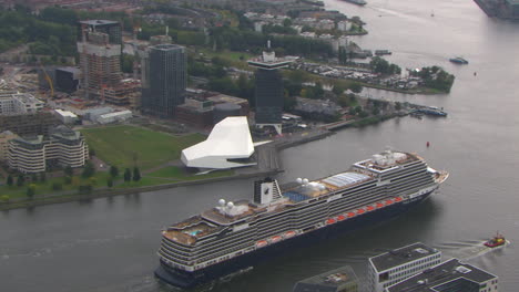 Aerial-establishing-shot-of-the-Eye-films-museum-in-Amsterdam-with-a-cruise-ship-pa