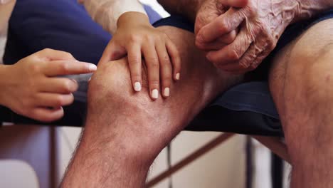 close-up of physiotherapist examining patients knee 4k