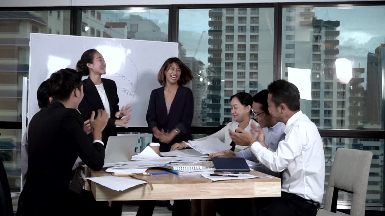 성공적인 아시아 사업가들은 프로젝트의 성공을 그룹 모임에서 축하합니다.
