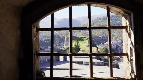 prisión dentro de un castillo medieval con mazmorra, siguiendo el tiro hacia la ventana cerrada por barras de hierro