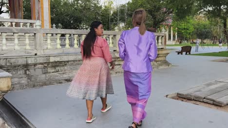 two women in traditional thai clothing at a temple