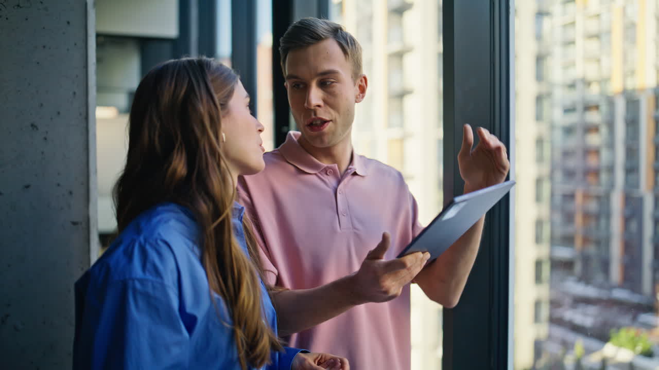 Couple colleagues discussing strategy talking at panoramic window office closeup