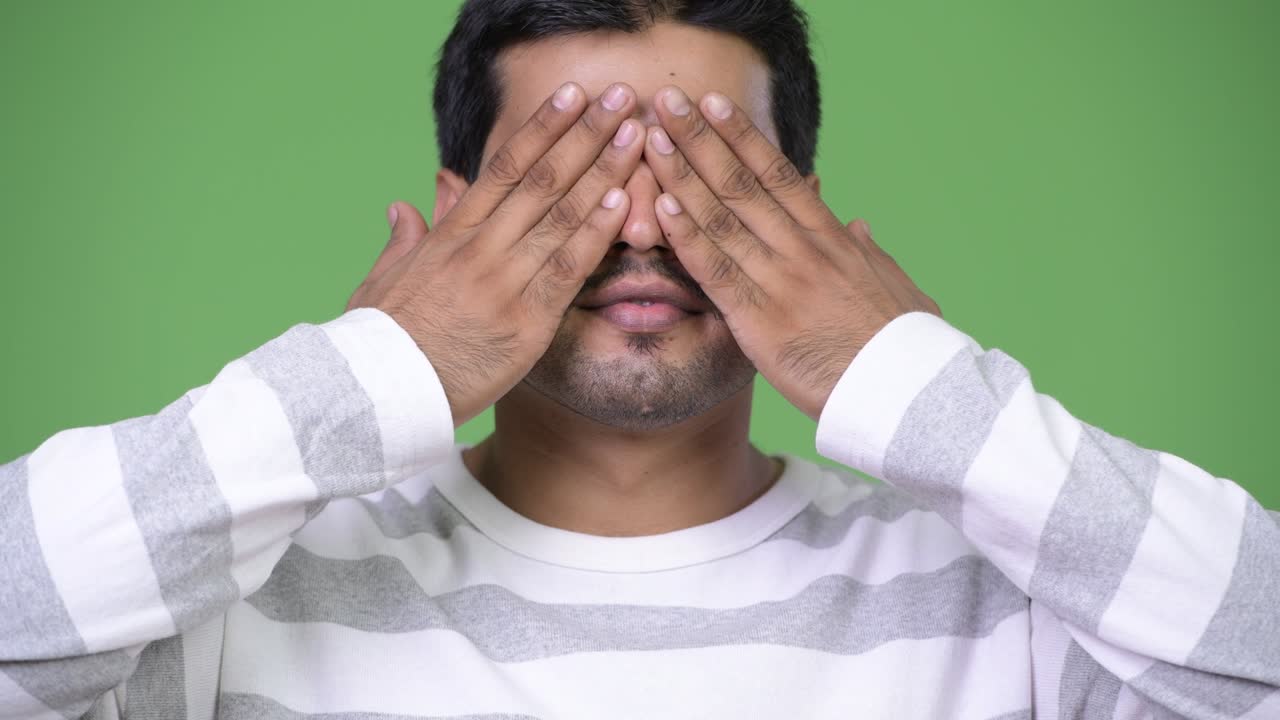 Young handsome Persian man covering eyes as three wise monkeys concept