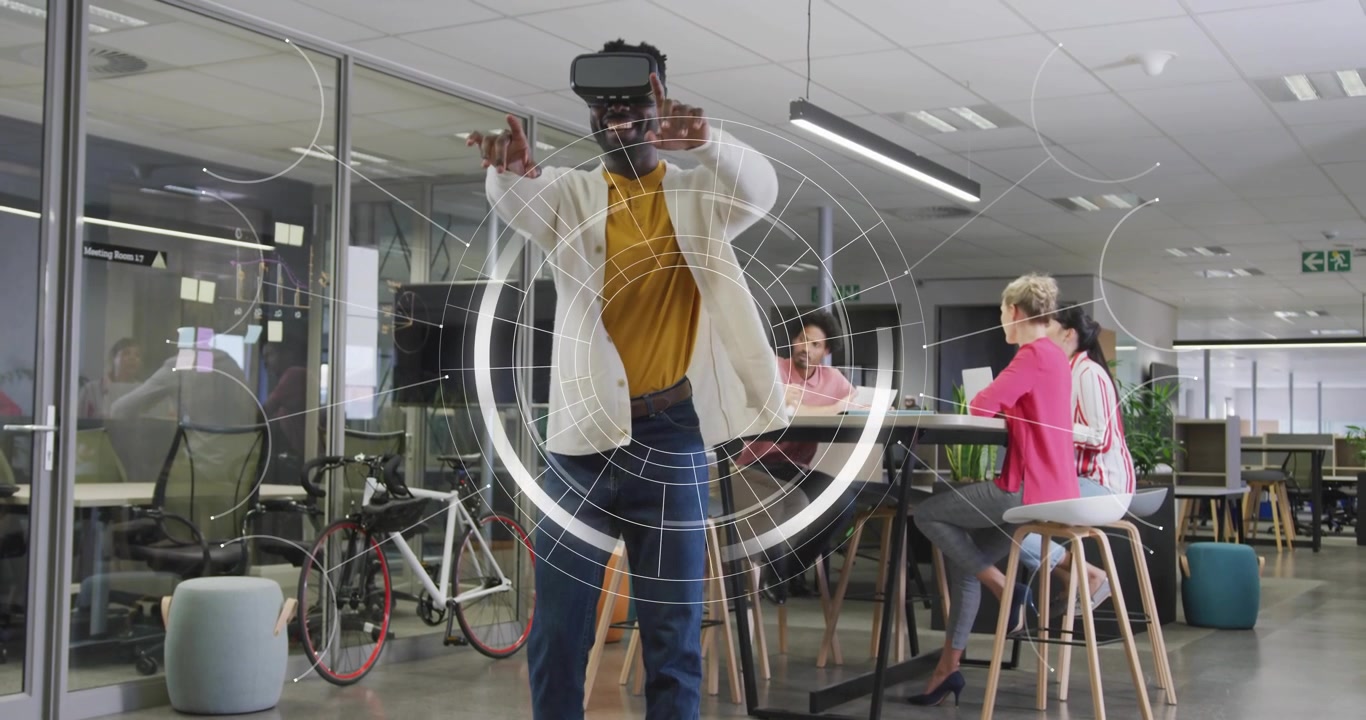 Uomo che indossa un visore VR e manipola anelli olografici in un ufficio tecnologico per la revisione del progetto del team.