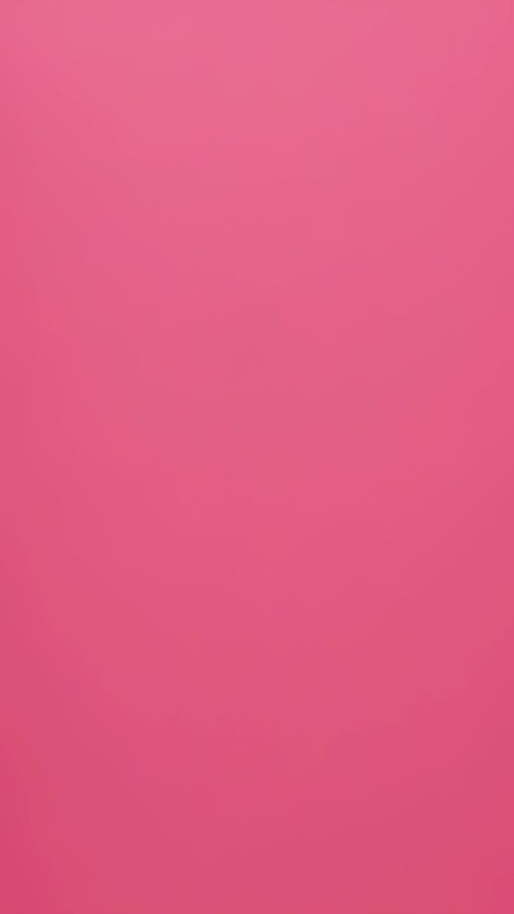 Vertical video: Showing pink painted wall shifting tone from subtle lighting shifts, no objects