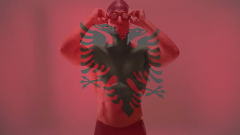 animation of flag of albania over caucasian male swimmer