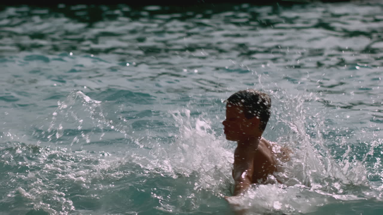 niño salpicando en una piscina